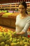 woman selecting fruit in grocery store
