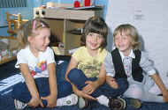 Three children sitting smiling